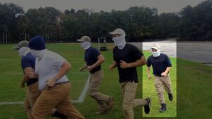 An image of Cerce jogging with other Patriot Front members in a Hopedale MA park during October 2021. Cerce, in his Patriot Front garb, visibly lags behind other members.
