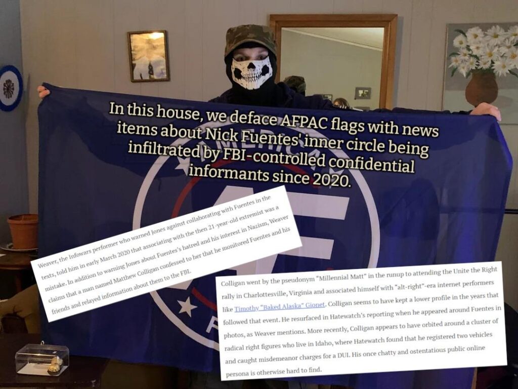 A photo of Langille holding an America First flag in front of himself, indoors. He wears a skull mask and a camo hat. In a mirror behind him, a shorter person with mid-length hair is partially visible. The flag is defaced with excerpts of a previously-linked article about Nick Fuentes and the America First PAC being infiltrated by FBI-controlled confidential informants, as reported by Michael Edison Hayden and Megan Squire via the Southern Poverty Law Center.