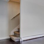 A specific photo from the previous Zillow listing. depicting a stairwell leading up. It appears virtually identically to the stairwell up which Behling's cat scampered in his Silver Stackers video, and is cropped in a similar aspect ratio to Behling's video.