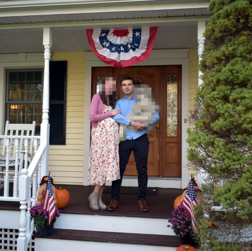 A photo of Patriot Front member Mark Hayden, his wife, and their child on the front porch of an unknown house. There are various autumnal decorations, including pumpkins on the porch.
